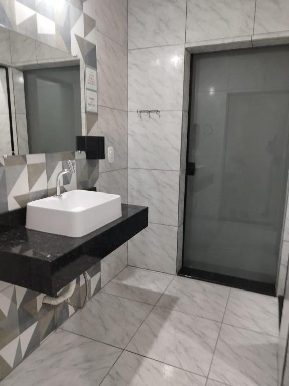 a bathroom with a sink and a shower with a mirror at Casa de Praia Família Próximo ao ExpoCentro BC in Balneário Camboriú