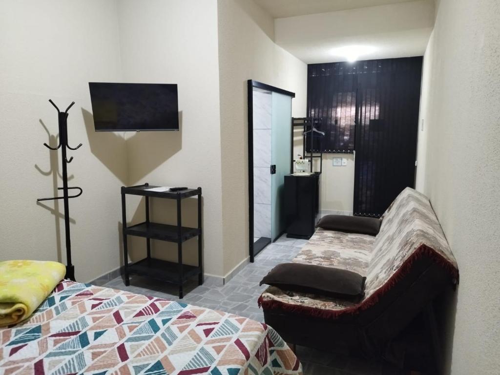 a bedroom with a bed and a tv and a mirror at Casa de Praia Família Próximo ao ExpoCentro BC in Balneário Camboriú