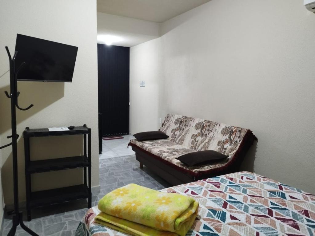 a living room with a couch and a bed at Casa de Praia Família Próximo ao ExpoCentro BC in Balneário Camboriú