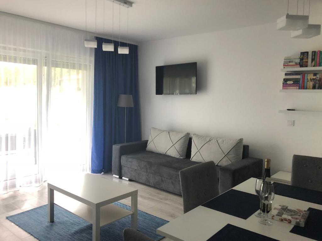 a living room with a couch and a table at Morski z ogródkiem in Pogorzelica