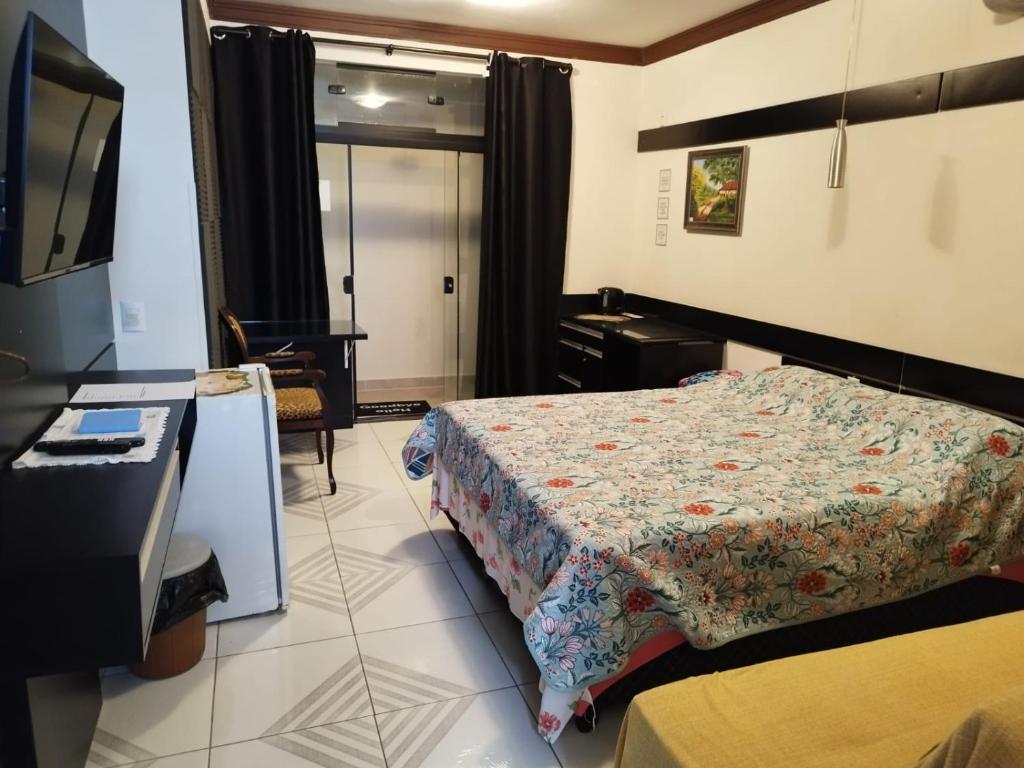 a hotel room with a bed and a television at Casa de Praia Família Próximo ao ExpoCentro BC in Balneário Camboriú