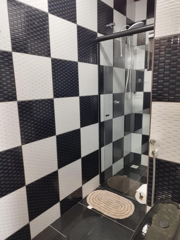 a bathroom with a shower with black and white tiles at Casa de Praia Família Próximo ao ExpoCentro BC in Balneário Camboriú