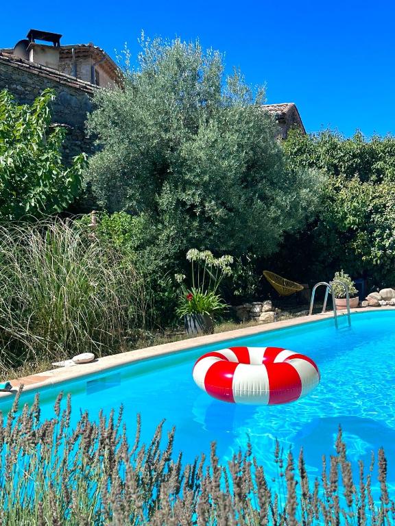 - une piscine avec un flotteur rouge et blanc dans l'établissement Les Cailloux Dorés, à Massillargues-Attuech