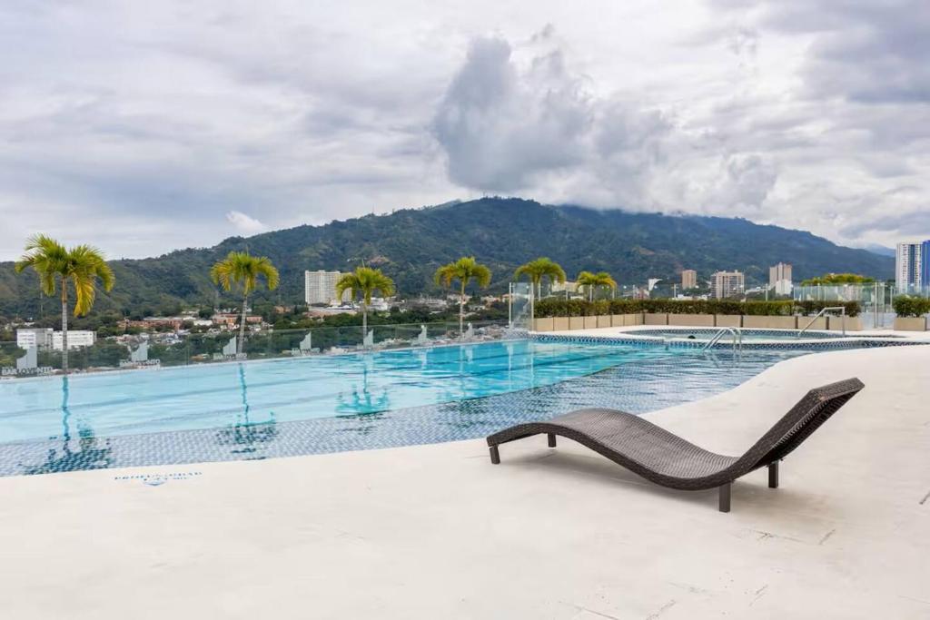 a swimming pool with a chaise lounge on a building at Apartamento Luxury ubicado en la mejor zona comercial de la ciudad in Ibagué