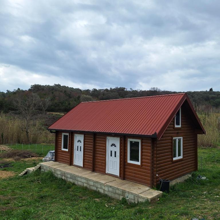 una piccola cabina con tetto rosso in un campo di Cottage Kolomza a Ulcinj