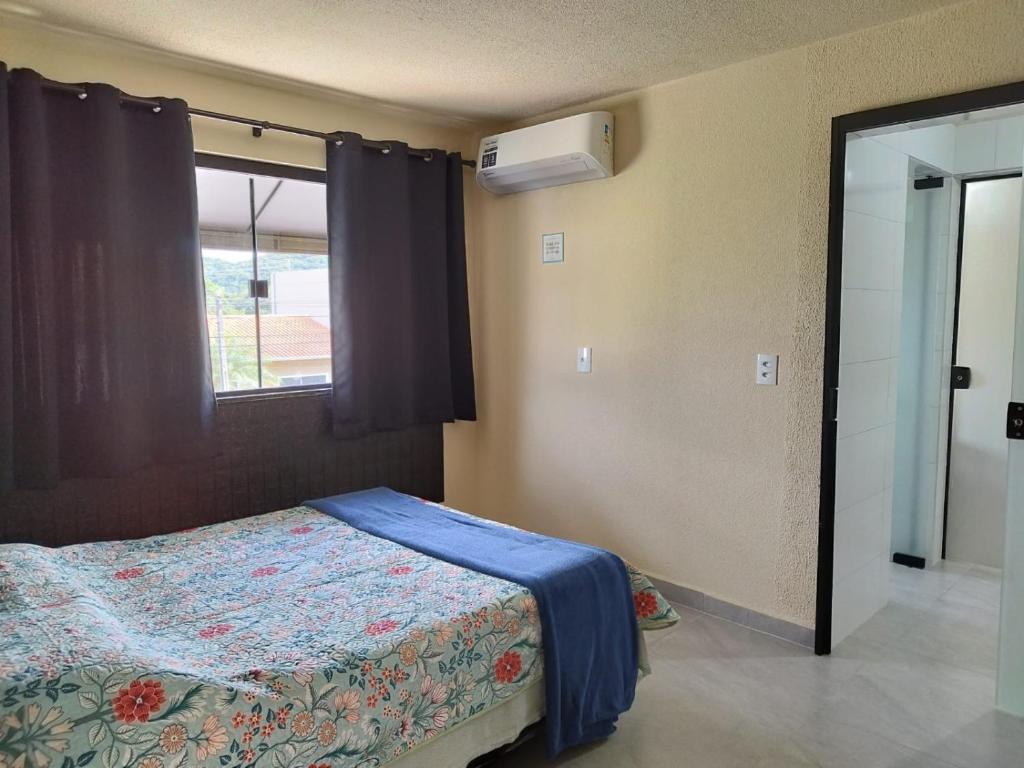 a bedroom with a bed and a window at Casa de Praia Família Próximo ao ExpoCentro BC in Balneário Camboriú
