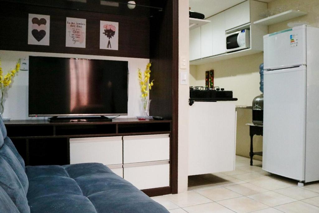Una sala de estar con televisión y un sofá. en Flat incrível em Olinda, en Olinda