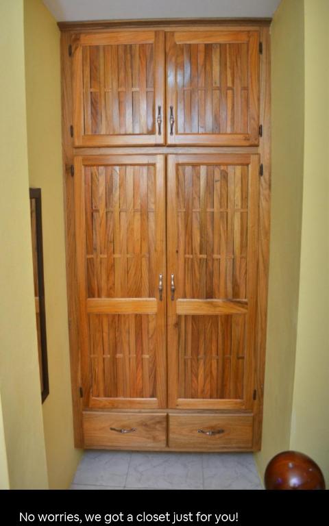 a wooden cabinet in a corner of a room at Essentials Suite in Bon Accord