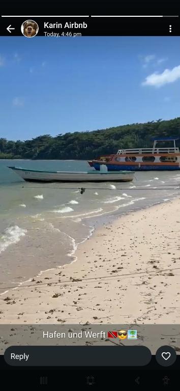 a picture of a beach with a boat in the water at Essentials Suite in Bon Accord