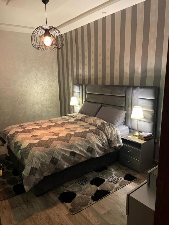 a bedroom with a bed and a striped wall at Luxurious apartment in Chefchaouene