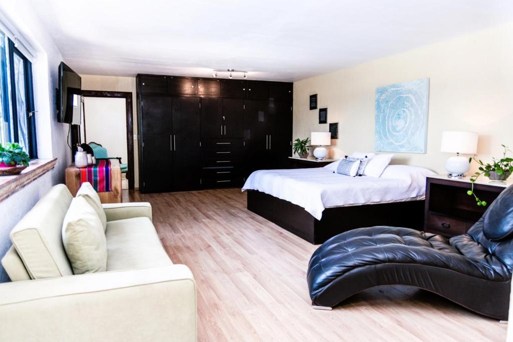 a bedroom with a bed and a couch at ANANA Rancho San Rafael | Master BD & Lake views in Ajijic