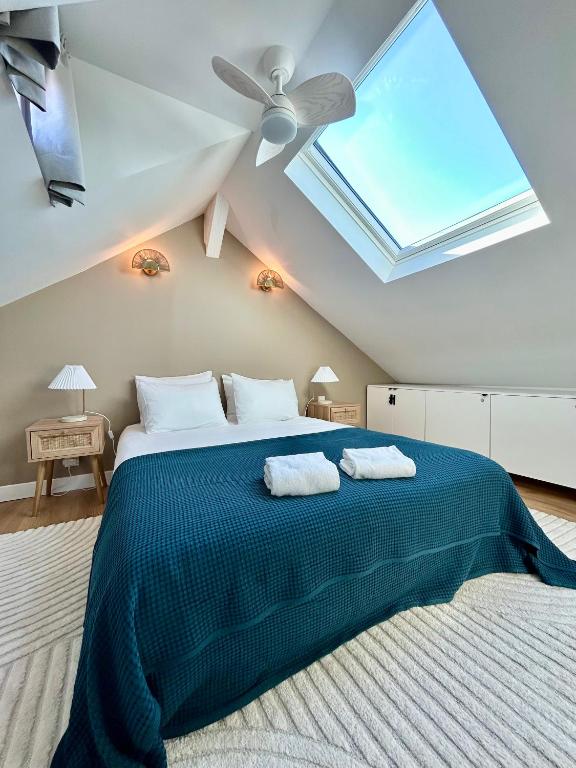 une chambre avec un grand lit avec une lucarne dans l'établissement La belle Deauvillaise, à Deauville