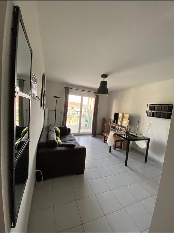 un salon avec un canapé et une table dans l'établissement Bel appartement dans une résidence avec piscine, à Roquebrune-sur Argens