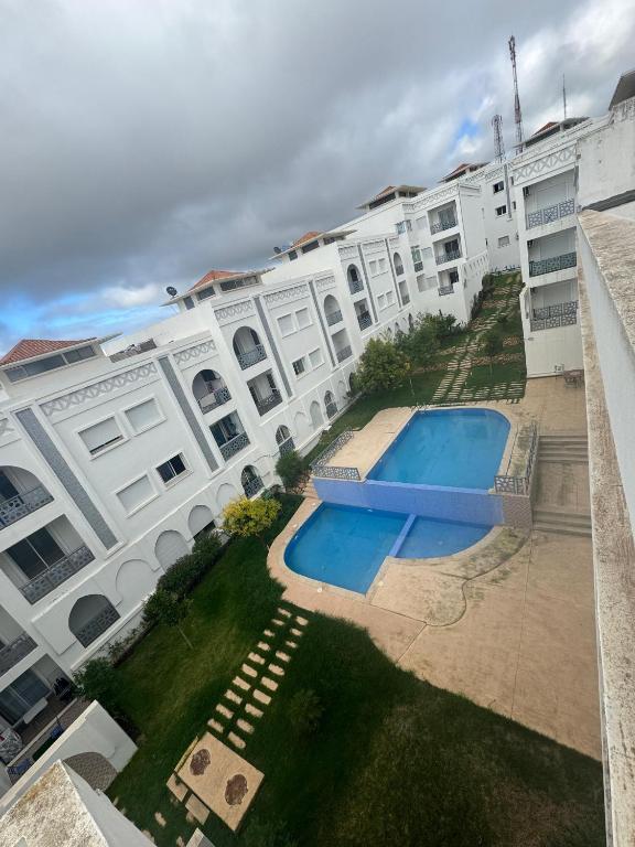 an overhead view of a large white building with a swimming pool at Appartement de luxe à Tanger Maroc in Tangier