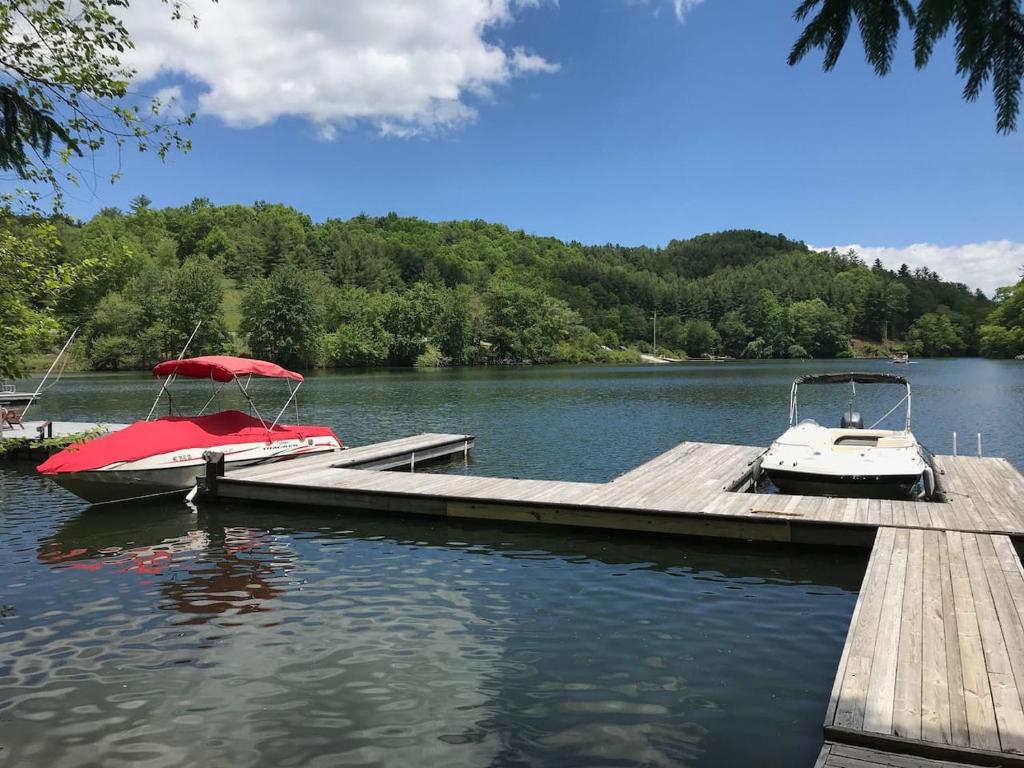 two boats are docked at a dock on a lake at Stunning Modern Rustic Lake Retreat PRVT BOAT SLIP in Cullowhee