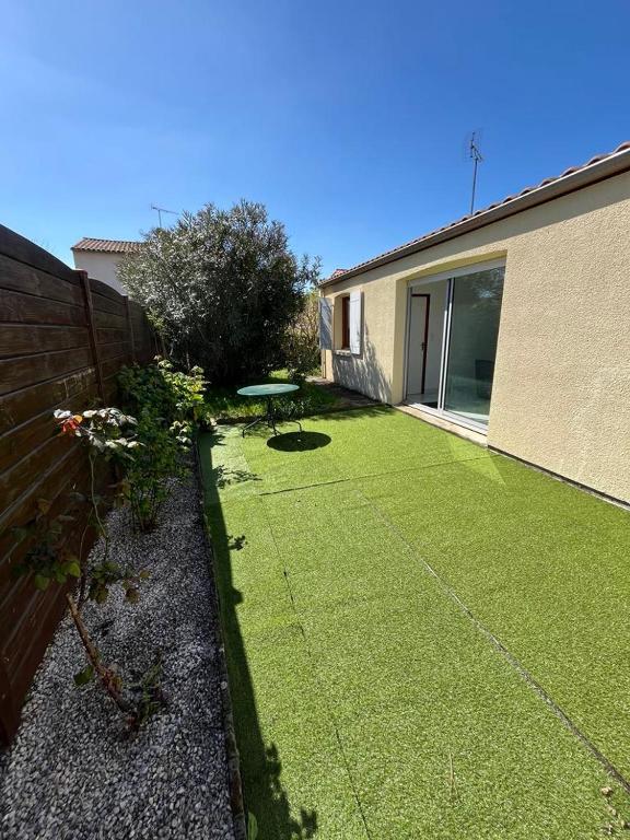 une cour avec une clôture et un banc dans l'établissement Maison 3 chambres - Royan, à Royan