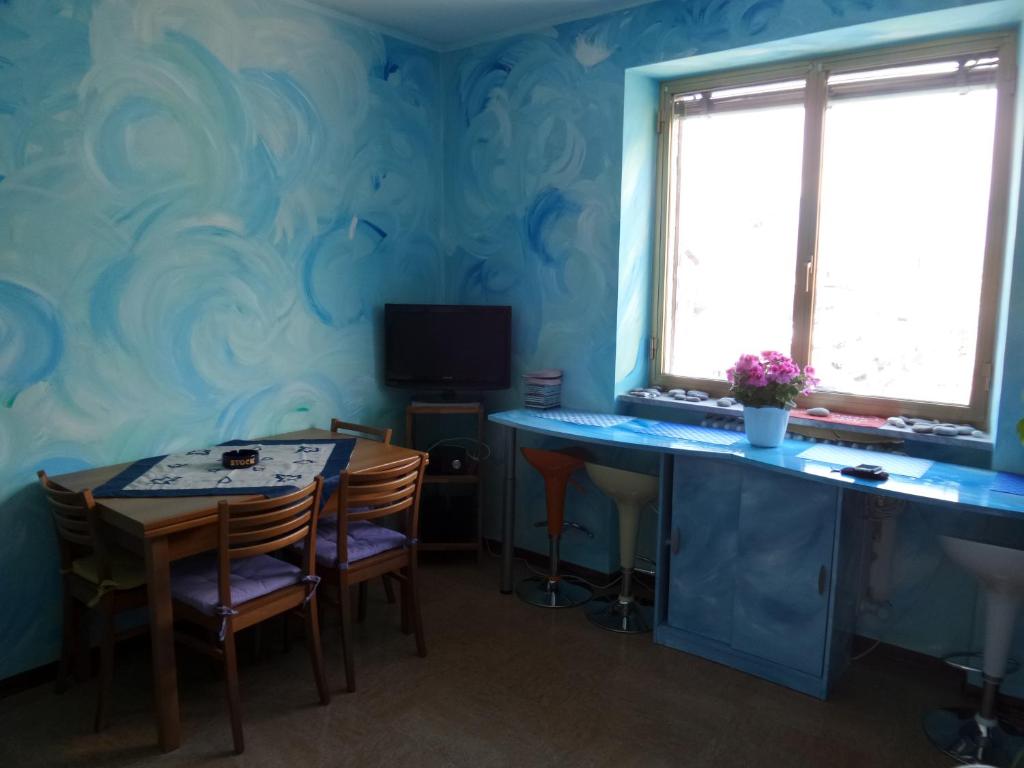 una sala da pranzo con pareti blu e tavolo e sedie di Alloggio azzurro CIR Aosta 0099 ad Aosta