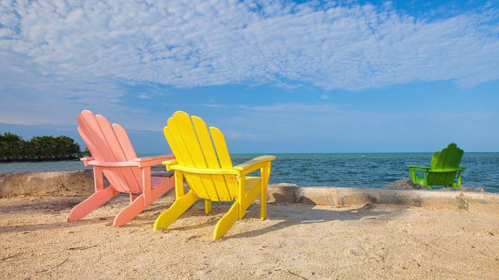 three chairs sitting on the beach near the water at 609 Mariners Club in Key Largo