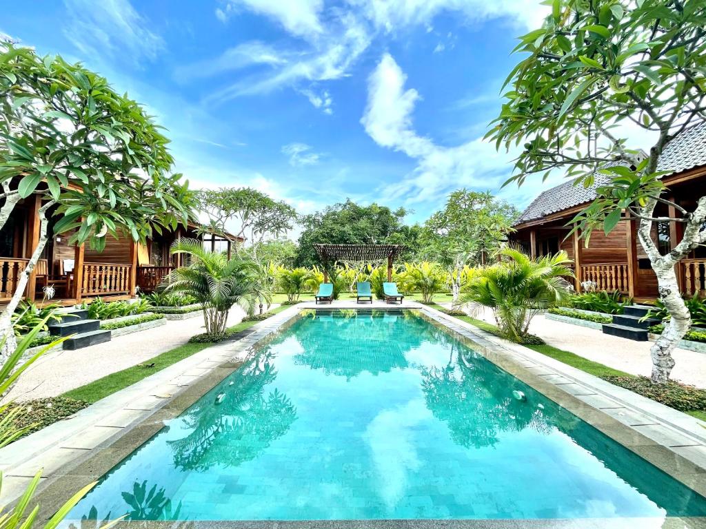 an image of a swimming pool in front of a house at Uluwatu Wooden Villa in Uluwatu