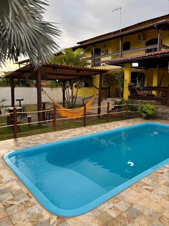 a large blue swimming pool in front of a house at Casa Barra Mar in Saquarema
