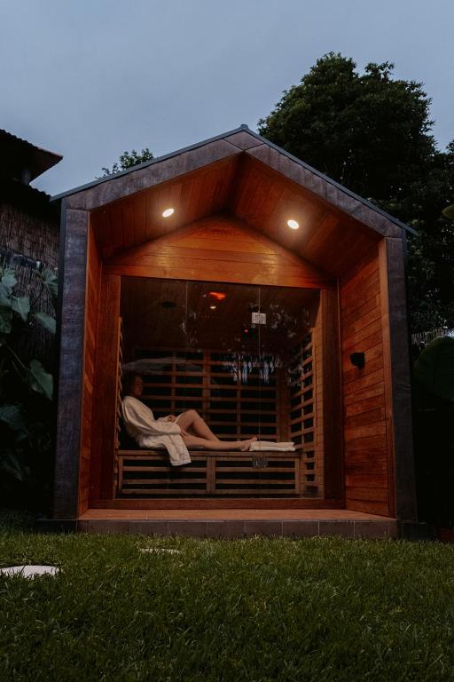 una persona seduta in una finestra in una casa per cani di Tiny home, Outdoor bath, Infrared Sauna, Fire pit a Cardiff