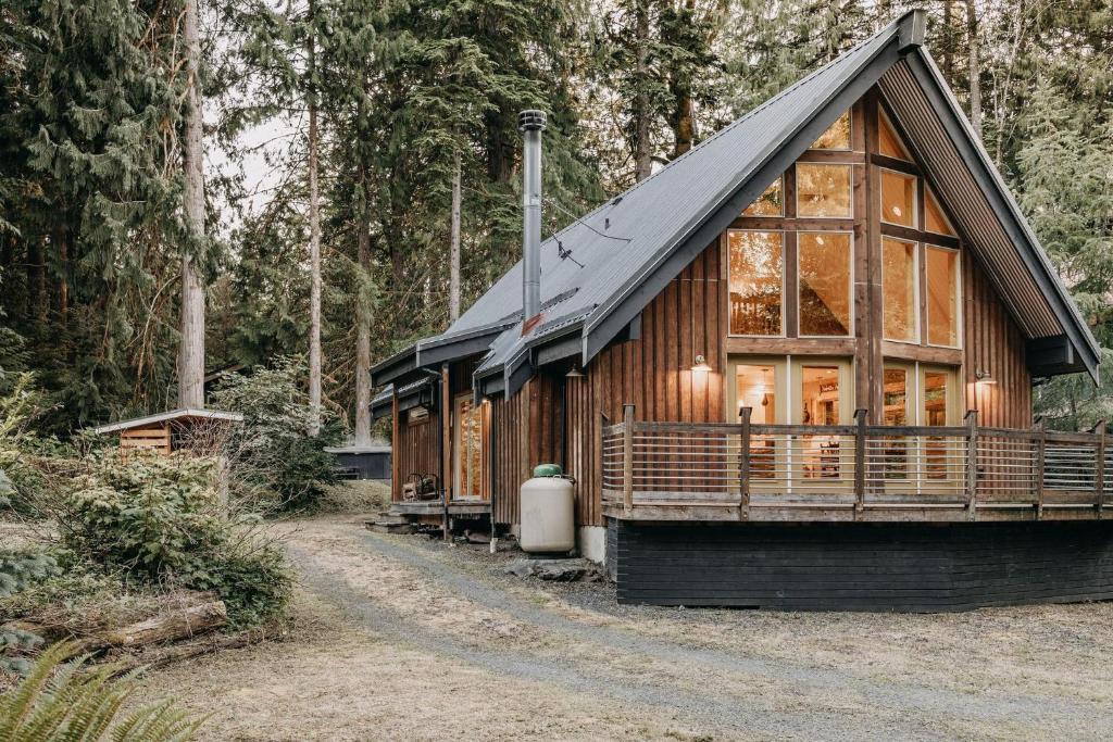 eine Hütte im Wald mit einem Walmdach in der Unterkunft 79MBR - Hot Tub - Pets Ok - WIFI - BBQ in Deming