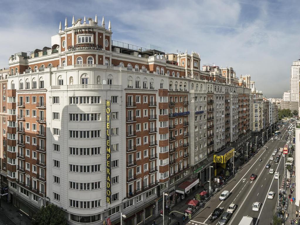 a large white building on a city street with traffic at Emperador in Madrid