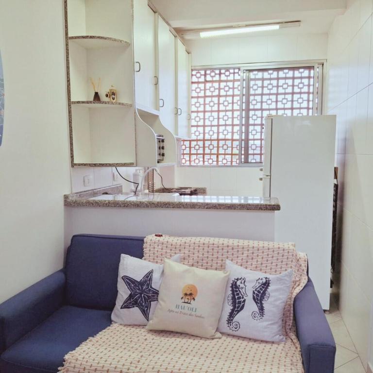 a blue couch with two pillows on it in a kitchen at Apartamento Confortável a 350m da Praia dos Sonhos Itanhaém in Itanhaém