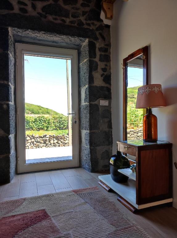 a room with a door and a lamp and a window at Armazéns do Beco - Cacau, Pimenta e Sal in Santa Cruz da Graciosa