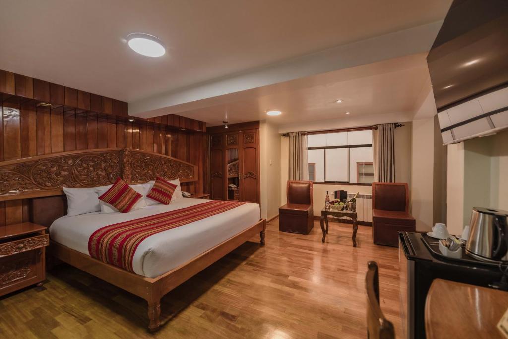 库斯科Quechua Hotel Cusco的房间里有一张床和一张书桌的卧室