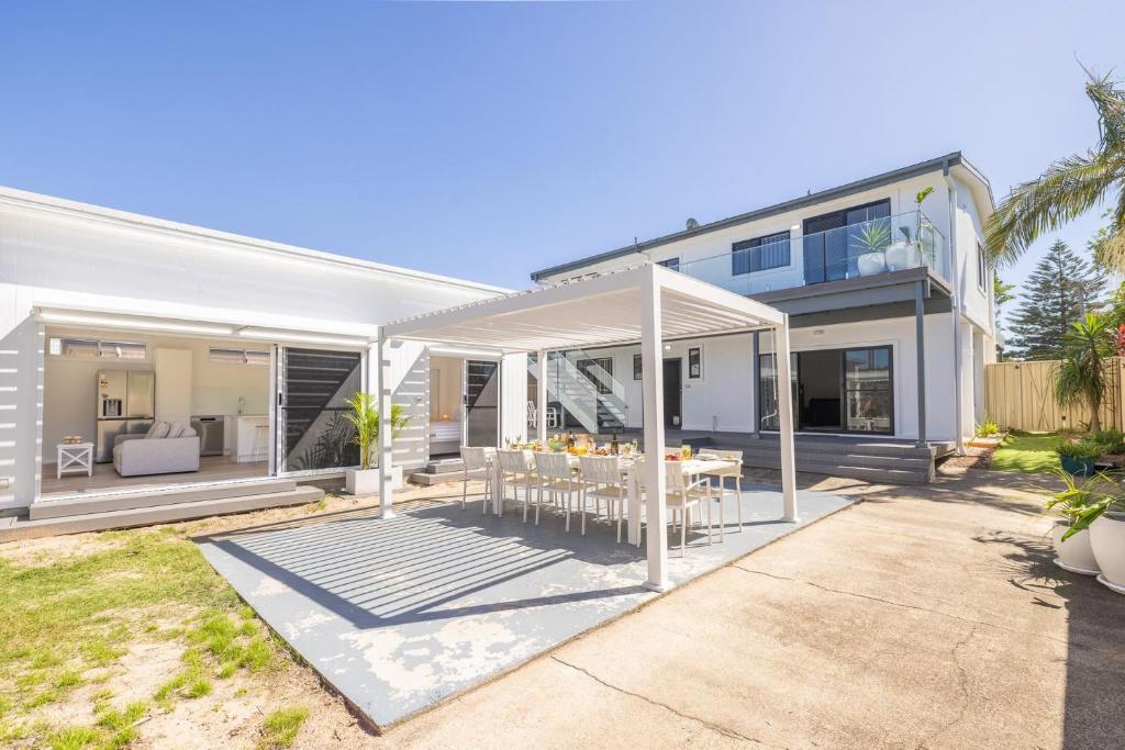 a house with a dining table in the backyard at Robinson Retreat with Beach Bungalow, 3 Robinson St - air con, 2 kitchens, 6 bedrooms, 4 bathrooms in Anna Bay