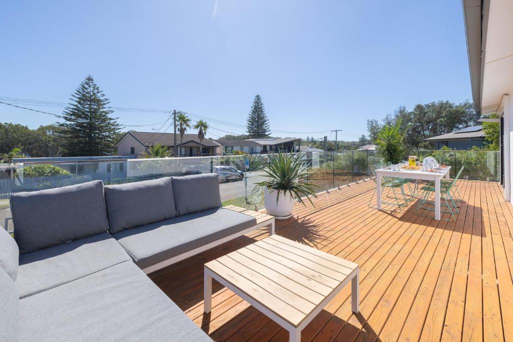 een patio met een bank en een tafel op een terras bij Robinson Retreat, 3 Robinson St - 4 bedrooms, 2 bathrooms, air con and Wi-Fi in Anna Bay