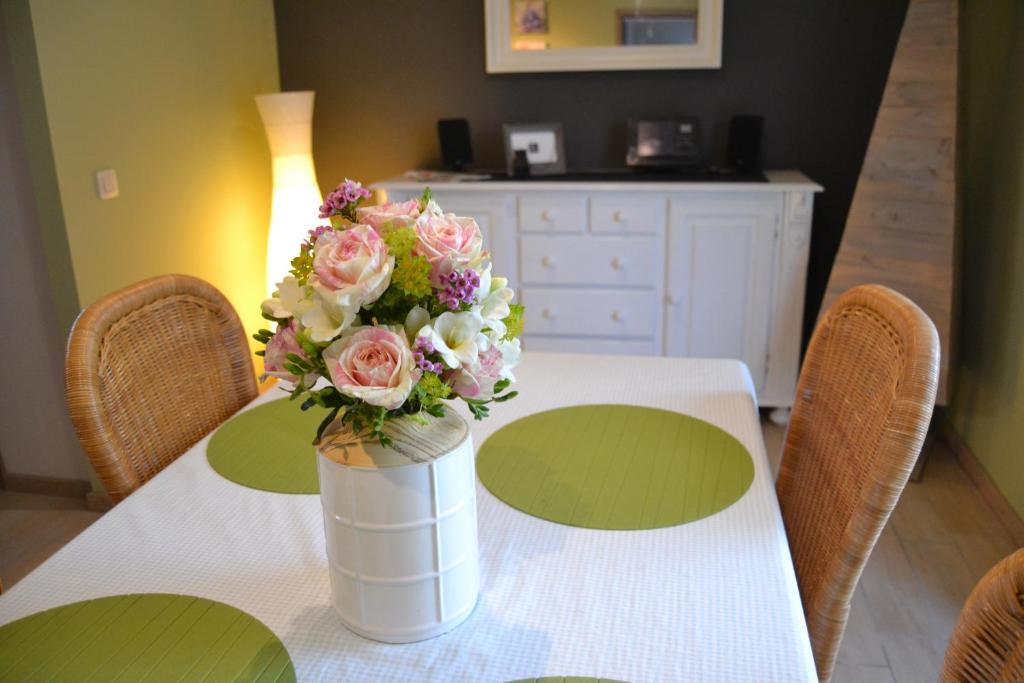 een tafel met een vaas met bloemen erop bij Gîte de l'Espinette in Godarville