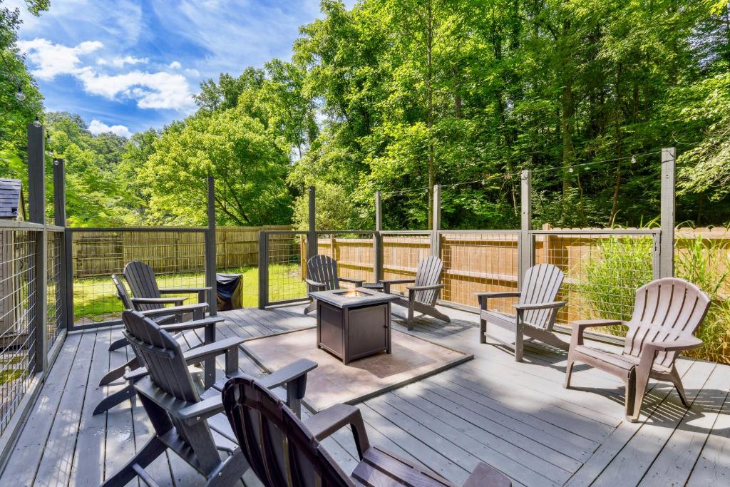 a deck with rocking chairs and a table and a fence at 3mil to Dwnt Gtbg 3Beds 2 Bath HotTub Fireplace Arcade Fire Pit in Gatlinburg