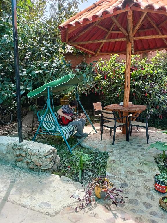 a person sitting in a chair under an umbrella at Hostal Ayllu con cochera in Urubamba