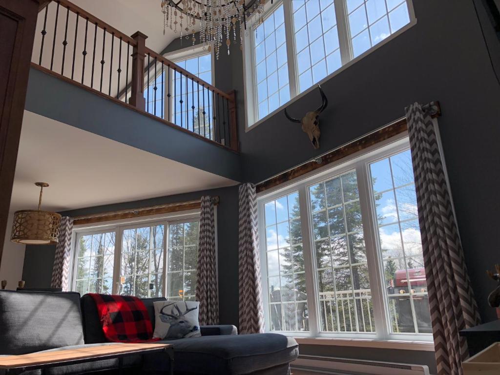 a living room with large windows and a couch at Night Sky Cottage in Saint-Joachim
