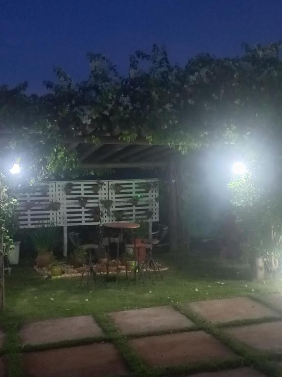 a backyard at night with a table and lights at Sitio trem bao demais in Mateus Leme