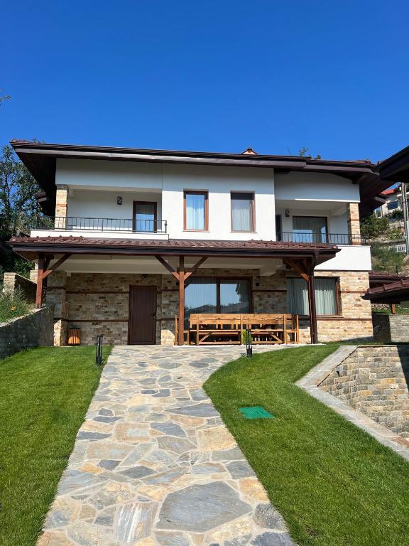 a house with a stone pathway in front of it at Spa Villas Daffi in Smolyan