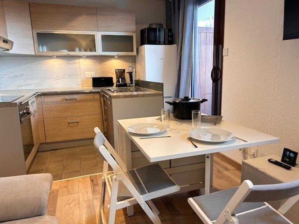 une cuisine avec une table et des chaises dans une pièce dans l'établissement Studio confortable à Risoul, proche pistes et commerces - FR-1-330-548, à Risoul