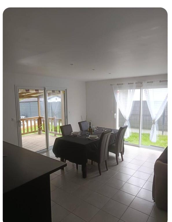 une salle à manger avec une table et des chaises dans une pièce dans l'établissement maison de vacances au calme avec espace jaccuzi, à La Turballe