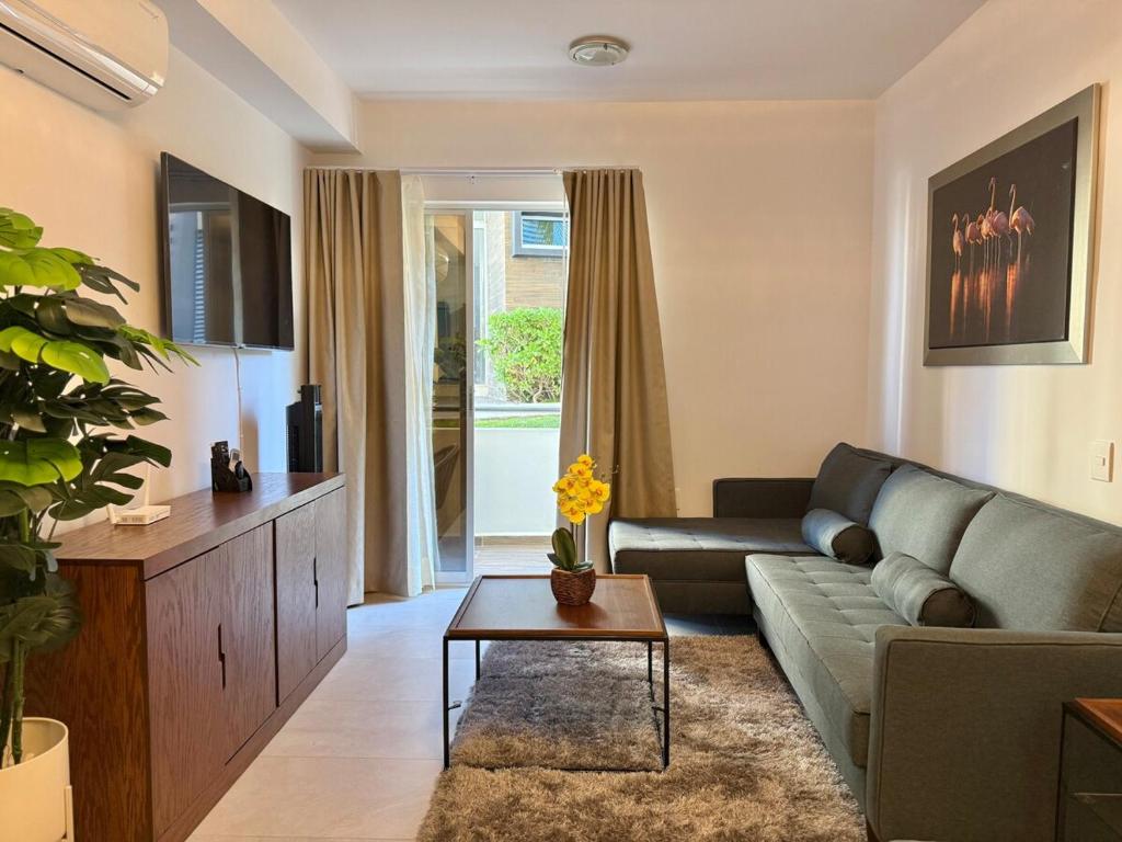 ein Wohnzimmer mit Sofa und Tisch in der Unterkunft Family apartment with great amenities - bluu 103 in Mazatlán