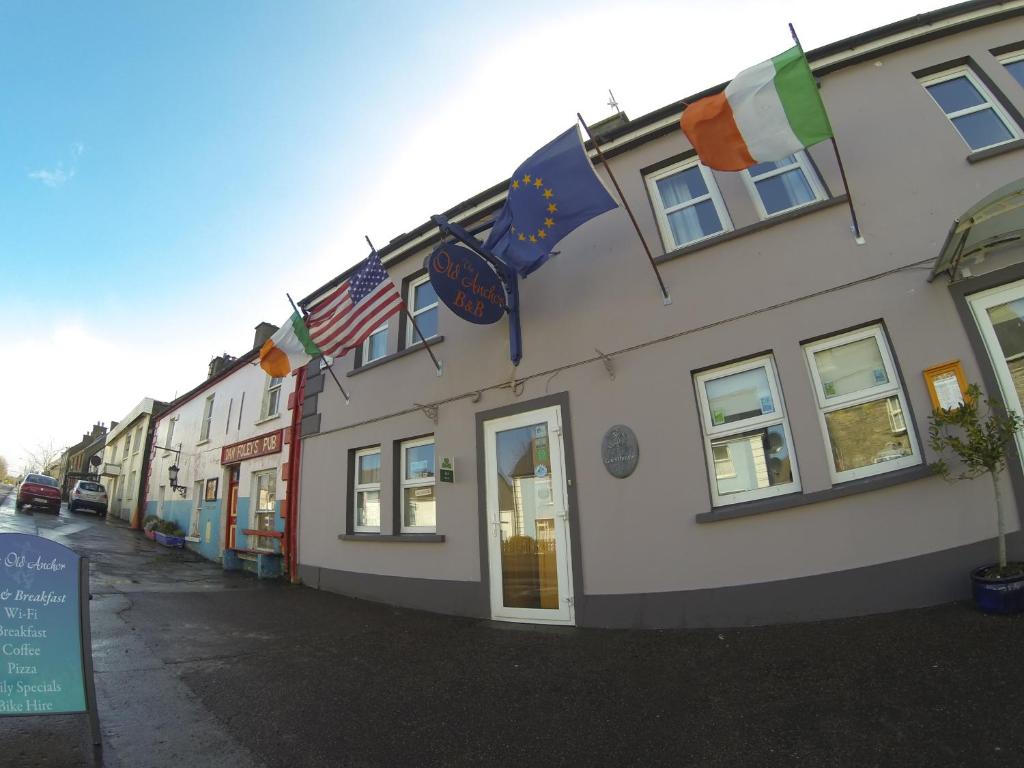 un edificio con banderas a un lado. en The Old Anchor B&B Annascaul, en Anascaul