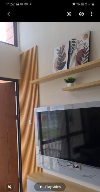a view of a living room with a tv and shelves at Shania home in Bogor