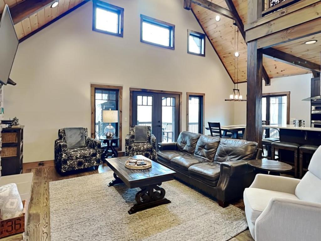 a living room with a leather couch and a table at Above it All in McHenry