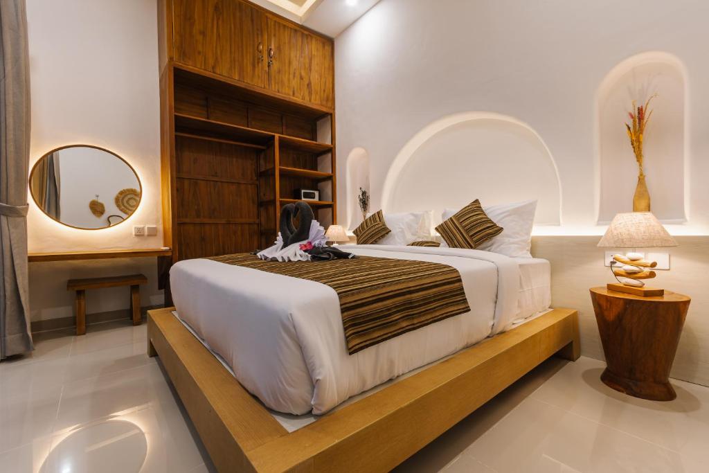 a bedroom with a large bed and a mirror at Villa Shekinah Oasis in Ubud