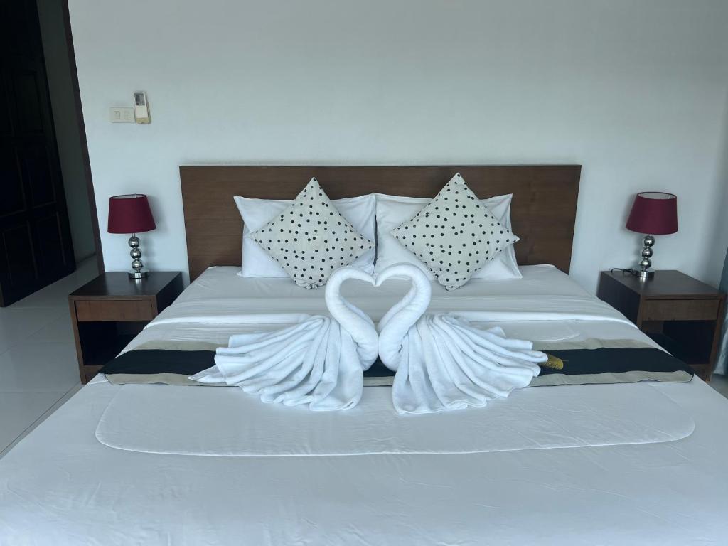 two heart shaped wings are on a bed at Nern Khao Guest House in Kamala Beach