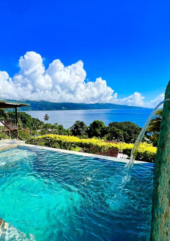 a swimming pool with a water fountain at Les Chalets de Afaahiti - Fare Keanu in Tiitau
