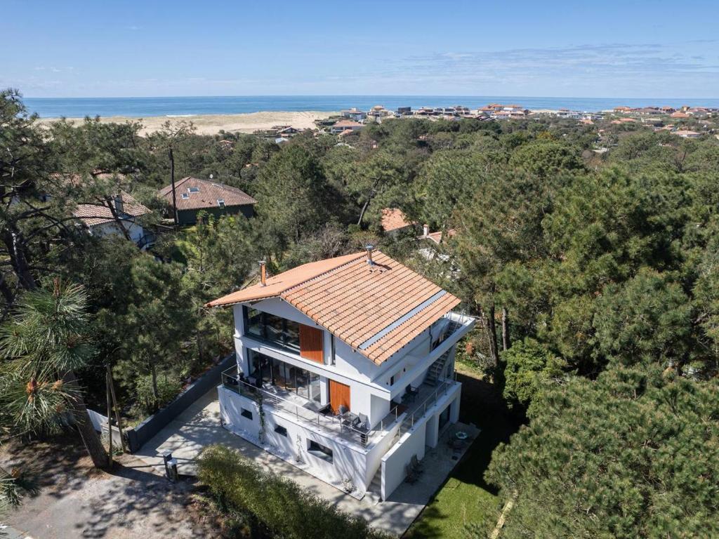 Cette chambre offre une vue sur une maison blanche dotée d'un toit en carrelage. dans l'établissement Villa luxueuse avec piscine privée à Hossegor - FR-1-791-2, à Soorts-Hossegor