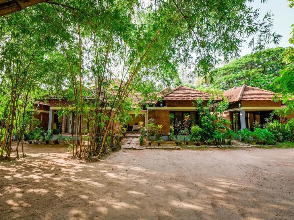 a house with trees in front of it at Kottaram Heritage Resort in Alleppey