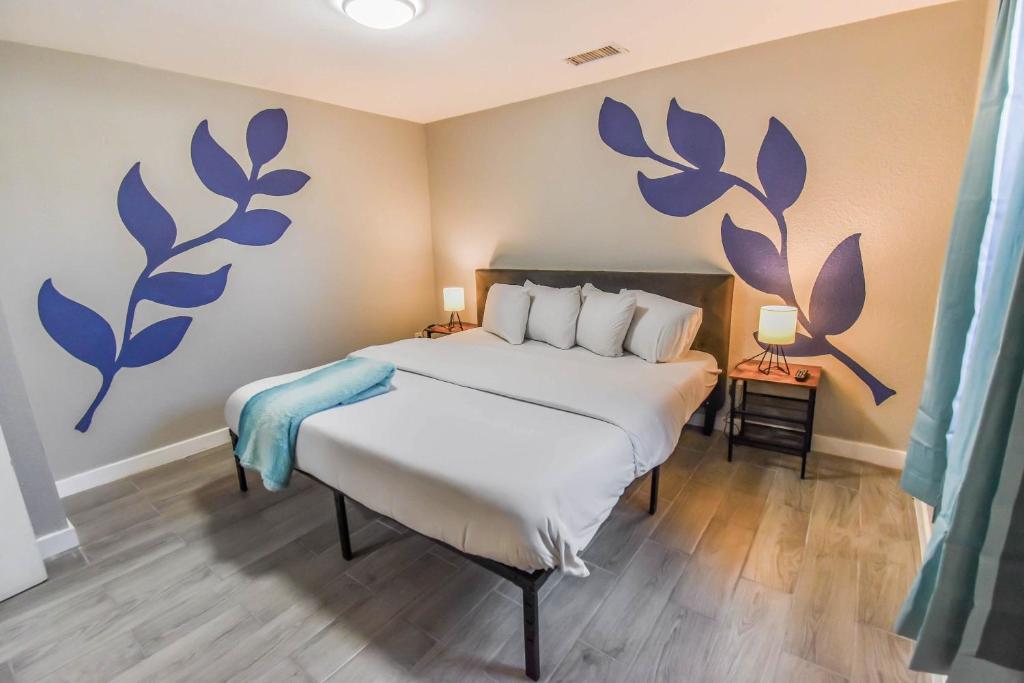 een slaapkamer met een bed met blauwe bloemen aan de muur bij Vibrant & Cozy Two Bedroom Lower Unit King Beds in Denver